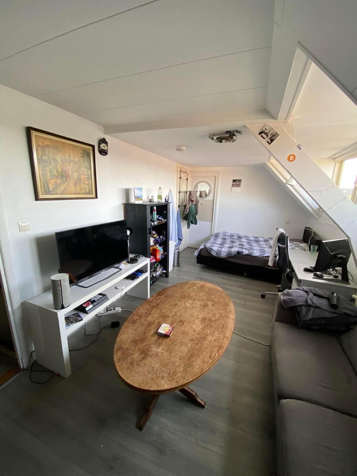 De kamer van Bjorn met een ovale tafel onder het schuine dak