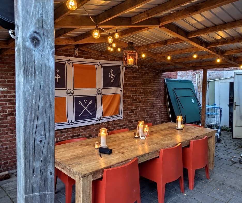 Overdekte eettafel in de tuin naast het P.E.B.-wapen